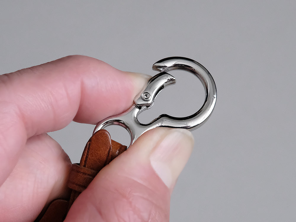 携帯しやすいよう、カラビナ式の金具にしました。片手で簡単に開閉できるため、脱着がスムーズに行えます。<br>
金具に細かな擦れキズなどが見られる場合がございます。